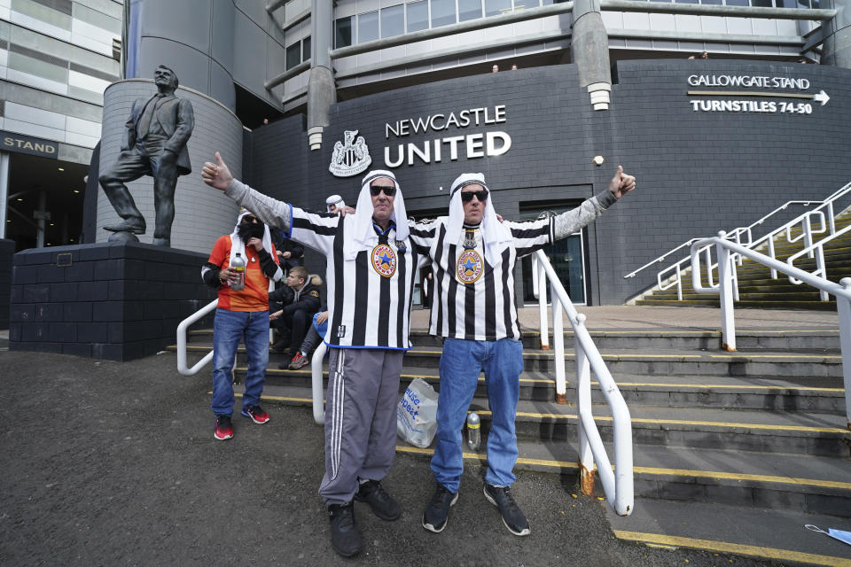 Newcastle fans pose for a photo outside the ground before an English Premier League soccer match between Newcastle and Tottenham Hotspur at St. James' Park in Newcastle, England, Sunday Oct. 17, 2021. Newcastle plays its first game under new ownership after the club was bought out last week by Saudi Arabia's sovereign wealth fund. (AP Photo/Jon Super)