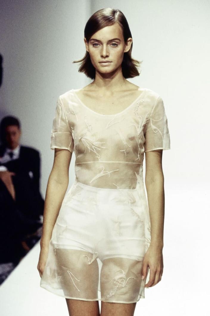 <p>Amber Valletta walked in a sheer sheath with hot shorts underneath at the spring/summer 1995 Prada show. </p>