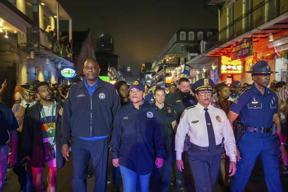 FILE - New Orleans Police Department Detective Louis Martinez Jr., next to New Orleans Mayor LaToya Cantrell, interim NOPD Superintendent Michelle Woodfork, Col. Lamar Davis of the Louisiana State Police, right, along with other members of law enforcement, NOFD and EMS walk down Bourbon Street just after midnight ceremoniously closing down Mardi Gras in New Orleans, Wednesday, Feb. 22, 2023. New Orleans District Attorney Jason Williams said Thursday, Feb. 23, 2023, that an assistant prosecutor wrongly decided to drop prosecution of more than a dozen illegal gun possession cases arising from Mardi Gras season arrests in exchange for the suspects' agreeing to forfeit their weapons. (David Grunfeld/The Times-Picayune/The New Orleans Advocate via AP, File)