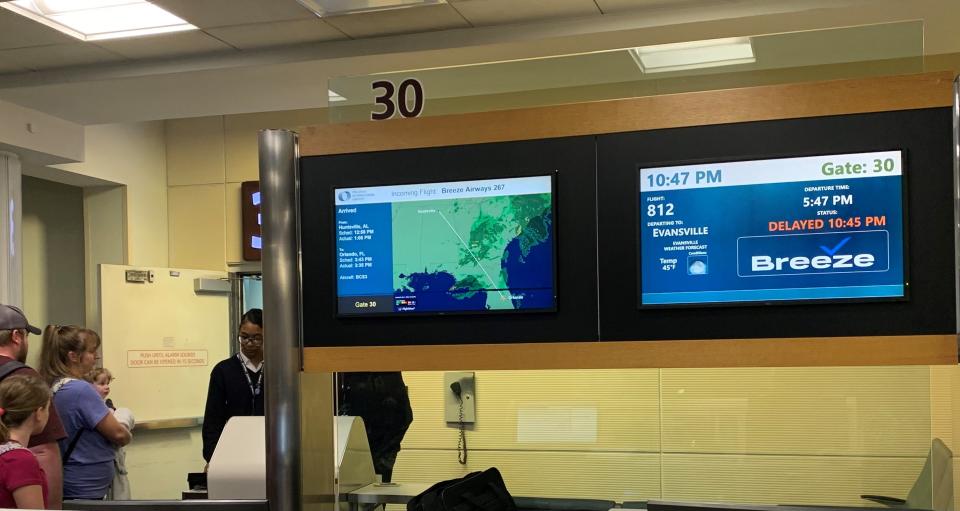 As passengers continue to board a flight to Evansville, Indiana, a five-hour delay is shown on the board of a Breeze Airways gate at Orlando International Airport Friday March 1, 2024.