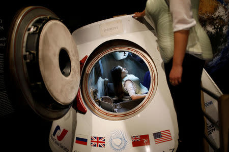 A woman wearing a prototype of Stemrad's new protective vest, Astrorad, sits inside Russian spacecraft, Excalibur-Almaz Space Capsule, during a demonstration for Reuters, at Madatech, National Museum of Science Technology and Space in Haifa, Israel February 23, 2017. Picture taken February 23, 2017. REUTERS/Amir Cohen