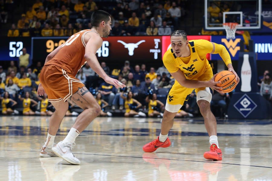 West Virginia forward Patrick Suemnick (24) is defended by Texas forward Brock Cunningham (30) during the second half of an NCAA college basketball game on Saturday, Jan. 13, 2024, in Morgantown, W.Va. (AP Photo/Kathleen Batten)