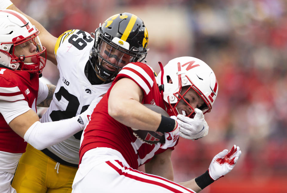 Iowa's Sebastian Castro, center, tackles Nebraska's Ty Hahn, right, while under pressure from Nebraska's Billy Kemp IV during the first half of an NCAA college football game Friday, Nov. 24, 2023, in Lincoln, Neb. (AP Photo/Rebecca S. Gratz)