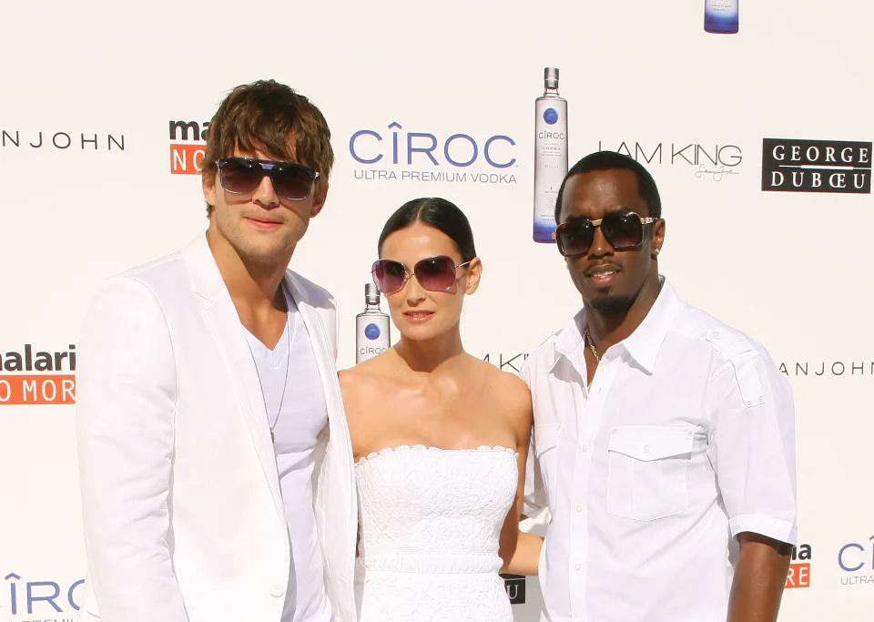 Then-couple Ashton Kutcher and Demi Moore pose with Diddy at the White Party in 2009. (Michael Tran/FilmMagic)