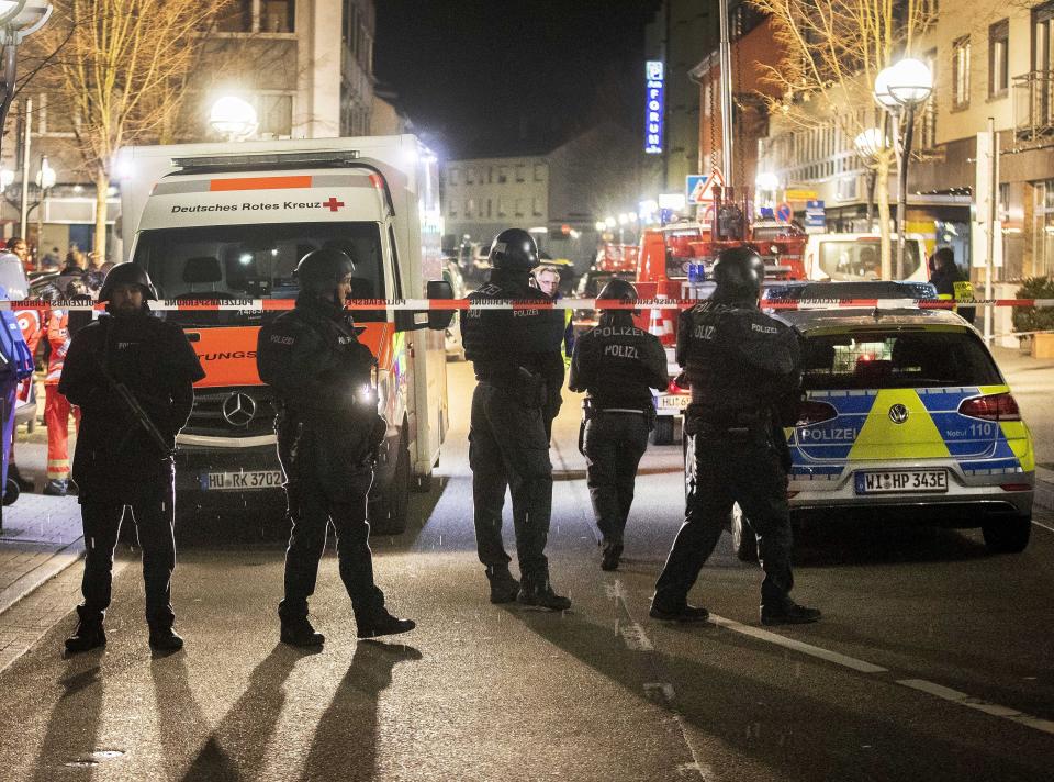 Police stand guard near the scene of a shooting in central Hanau, Germany Thursday, Feb. 20, 2020. German police say several people were shot to death in the city of Hanau on Wednesday evening. (AP Photo/Michael Probst)