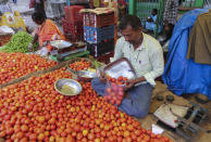 A vendor puts tomatoes in a single use plastic cover at a wholesale vegetable market in Hyderabad, India, Thursday, June 30, 2022. India banned some single-use or disposable plastic products Friday as a part of a longer federal plan to phase out the ubiquitous material in the nation of nearly 1.4 billion people. (AP Photo/Mahesh Kumar A.)