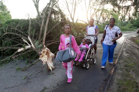 A family leaves their apartment complex in the morning after a tornado touched down overnight in Trotwood