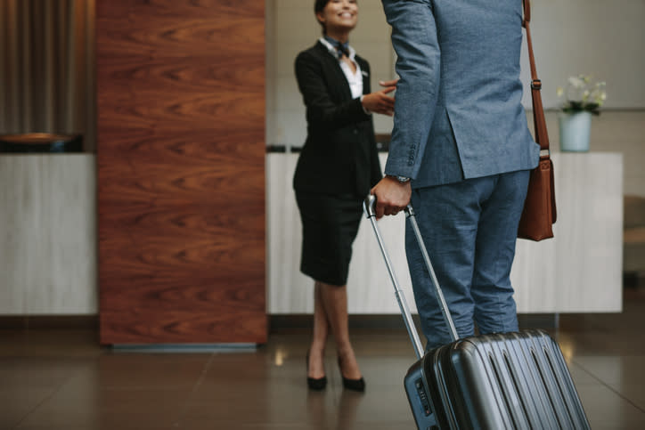 Businesswoman greeting a colleague with luggage in a hotel lobby