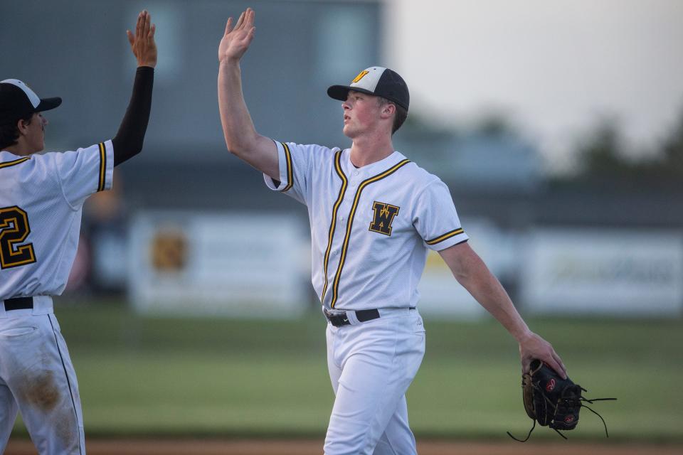 Winterset pitcher Justin Hackett gets a high-five from a teammate in a game against Carroll on Tuesday at Winterset High School. Hackett, who committed to TCU, is one of the top high school pitchers in the state.