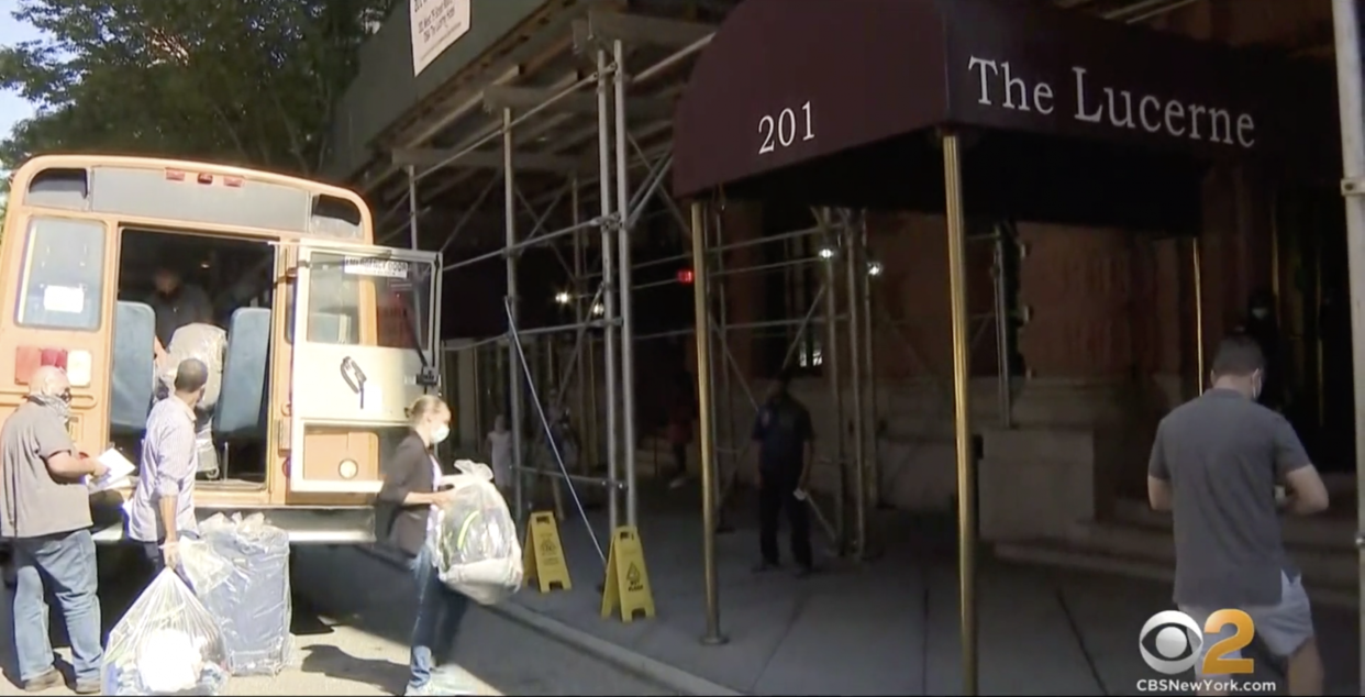 People carry their belongings into the Lucerne Hotel in Manhattan's Upper West Side: Screengrab / CBS