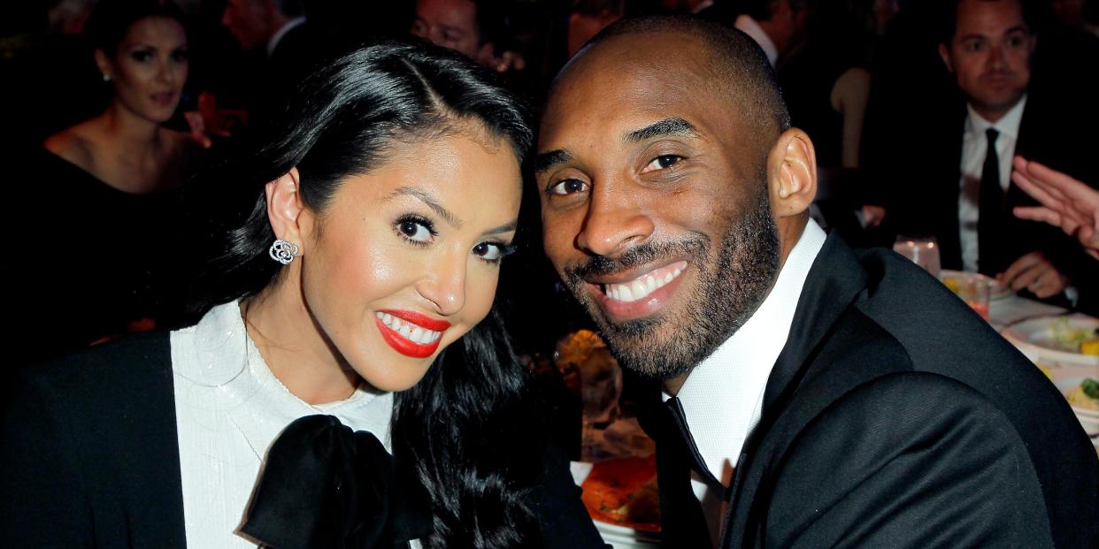 Vanessa Bryant (left) and Kobe Bryant (right) touching heads to pose for a photo in black and white attire