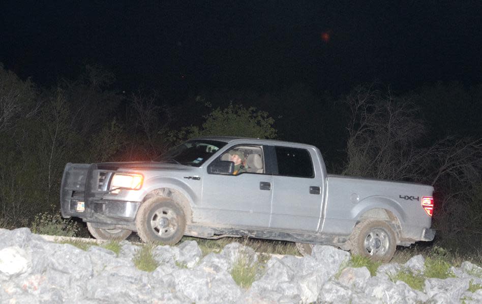 A Border Patrol agent in an unmarked vehicle drives out of US Fish and Wildlife land where a fellow agent was suspected of stabbing a woman and a child, as well as kidnapping another child Wednesday March 12, 2014, near Abram, Texas. Esteban Manzanares kidnapped and assaulted three immigrants from Honduras. Manzanares shot himself in the head killing himself before FBI agents entered his apartment. (AP Photo/The Monitor, Nathan Lambrecht)