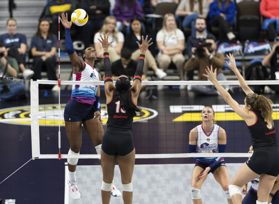 Omaha Supernovas' Nia Kai Reed, left, hits against Atlanta Vibe's Leah Edmond, second left, and Shelly Fanning, right, during a Pro Volleyball Federation game Wednesday, Jan. 24, 2024, in Omaha, Neb. (AP Photo/Rebecca S. Gratz)