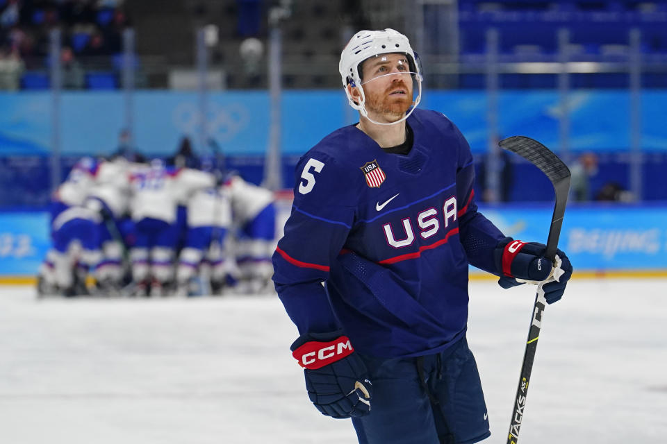 United States' David Warsofsky (5) looks at the scoreboard as Slovakia players celebrate behind him after a men's quarterfinal hockey game at the 2022 Winter Olympics, Wednesday, Feb. 16, 2022, in Beijing. Slovakia won 3-2 in a shoot-out. (AP Photo/Matt Slocum)