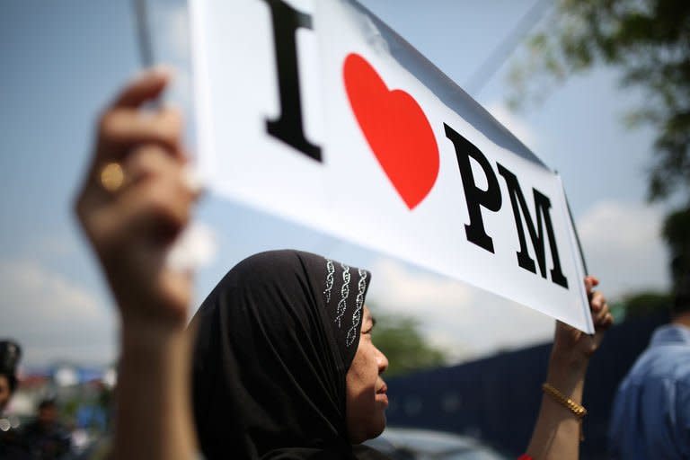 A Barisan National party supporter displays a placard during a campaign rally in Kuala Lumpur on April 22, 2013. Malaysia is bracing for long-anticipated elections that have raised speculation of the country's first change of regime since independence from Britain in 1957