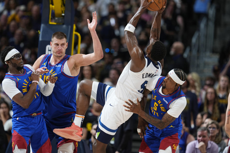 Minnesota Timberwolves guard Anthony Edwards, third from left, drives to the basket as, from left, Denver Nuggets guard Reggie Jackson, center Nikola Jokic and guard Kentavious Caldwell-Pope defend in the first half of Game 1 of an NBA basketball second-round playoff series Saturday, May 4, 2024, in Denver. (AP Photo/David Zalubowski)