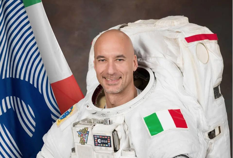 a man poses for a picture in a white space suit