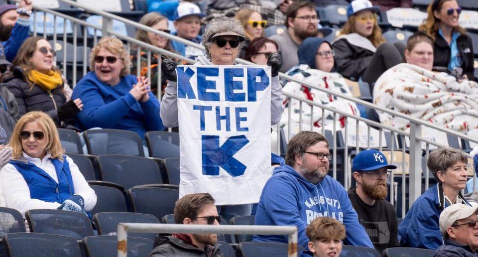 A Kansas City Royals fan holds up a sign in support of keeping Kauffman Stadium over a planned downtown stadium during a team practice on Wednesday, March 27, 2024, in Kansas City.