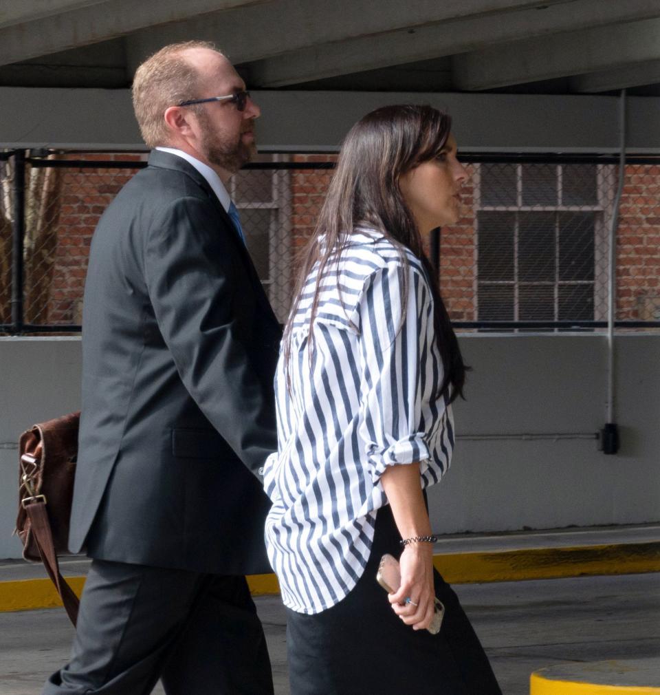 Patrick Walsh (left) holds hands with his wife as they walk along Southeast Second Ave in Gainesville, Fla. to their cars on Tuesday, Jan. 31, 2023. Walsh avoided questioning.