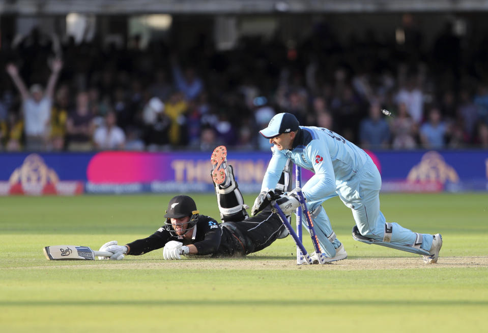 England's Jos Buttler runs out New Zealand's Martin Guptill during the Super Over in the Cricket World Cup final match between England and New Zealand at Lord's cricket ground in London, England, Sunday, July 14, 2019. (AP Photo/Aijaz Rahi)