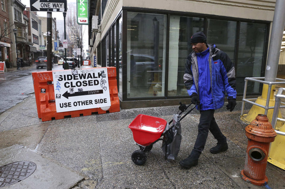 <p>Alpha Souare salts a sidewalk ahead of the snowstorm in Philadelphia on March 7, 2018. (Photo: Jessica Griffin/The Philadelphia Inquirer AP) </p>