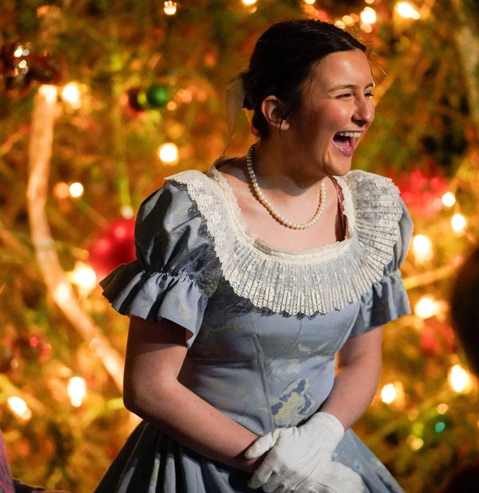 Savannah Christian, a member of the Tuscaloosa Cameo Guild, laughs in front of a Christmas tree as she talks with friends during the Dickens Downtown celebration on Main Ave. in Northport Wednesday, Dec. 5, 2023.