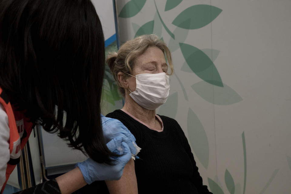 Esther Pamensky, a volunteer with the women's unit of United Hatzalah emergency service, administers a fourth dose of the COVID-19 vaccine to a woman at Clalit Health Services in Mevaseret Zion, Tuesday, Jan. 11, 2022. (AP Photo/Maya Alleruzzo)