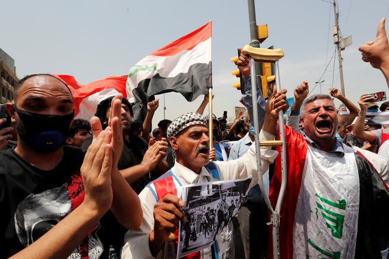 Iraqi demonstrators gesture as they attend the funeral of a protester, who was killed last night during the ongoing anti-government protest due to poor public services at Tahrir Square in Baghdad