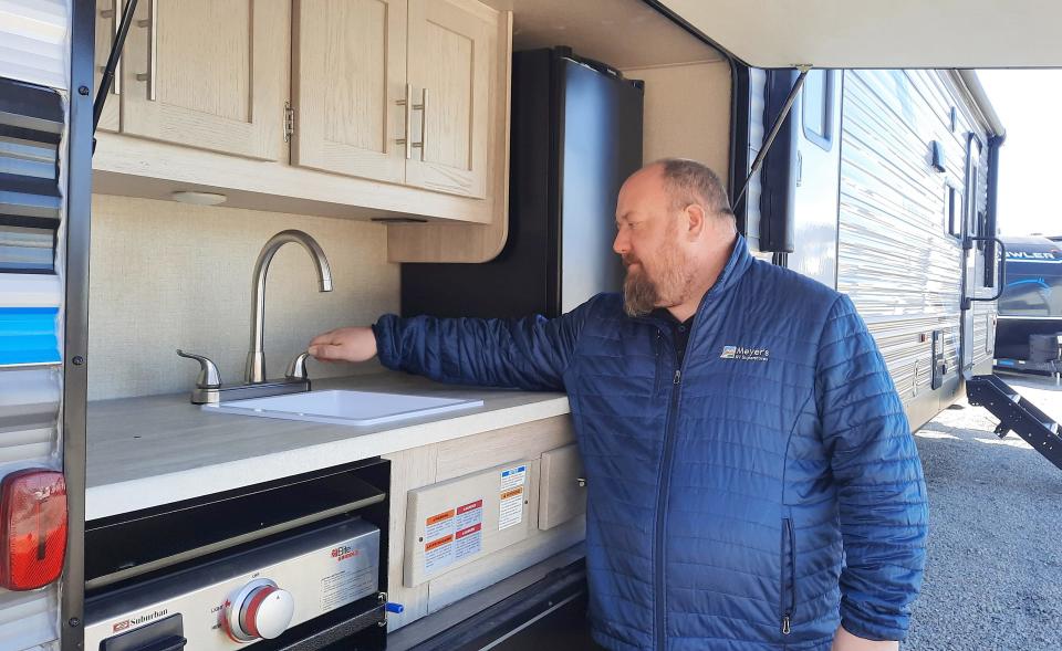 Chris Park, general sales manager at Meyer's RV in Mount Morris, checks on a faucet March 16 in an outdoor kitchen of a camper.