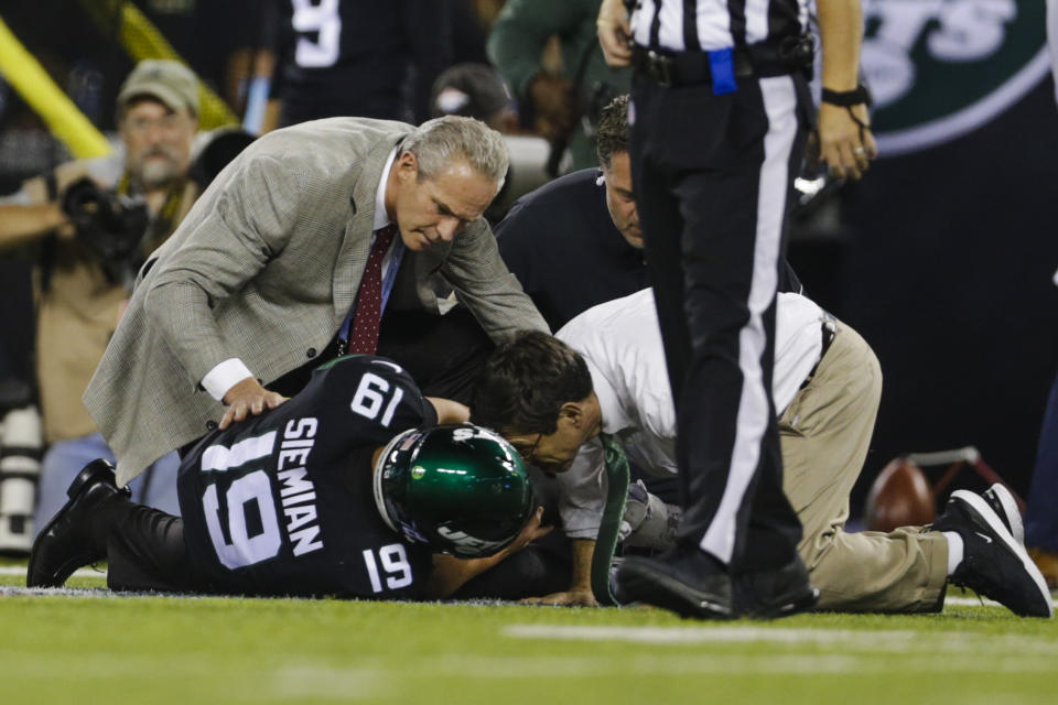 Trainers check on New York Jets quarterback Trevor Siemian (19) after he was injured during the first half of an NFL football game against the Cleveland Browns, Monday, Sept. 16, 2019, in East Rutherford, N.J. (AP Photo/Adam Hunger)