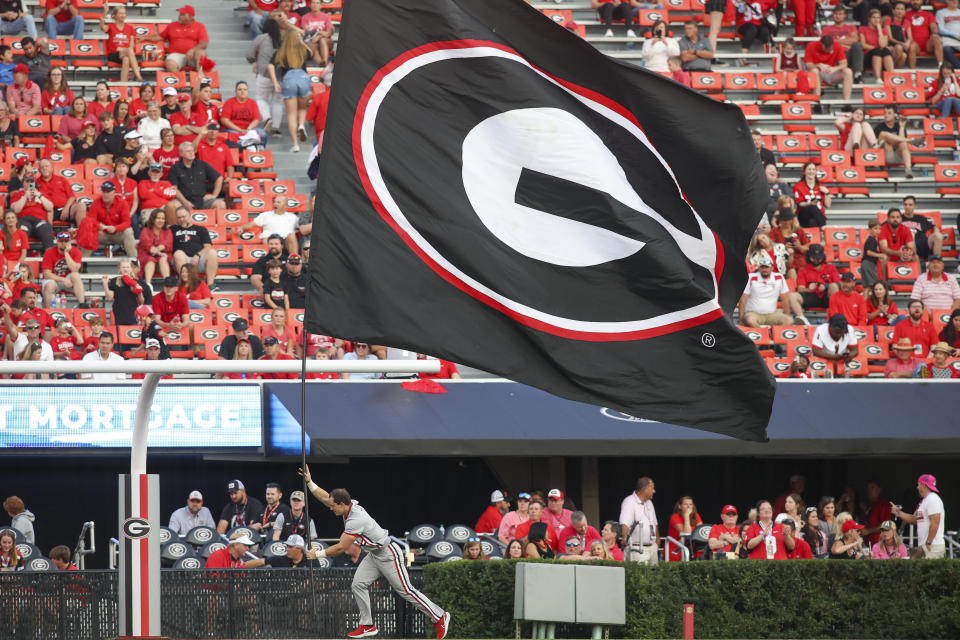 A Georgia cheerleader runs a flag across the end zone after a touchdown in the second half of an NCAA college football game against Vanderbilt, Saturday, Oct. 15, 2022, in Athens, Ga. (AP Photo/Brett Davis)