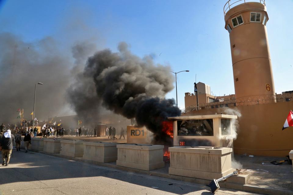 Protesters burn property in front of the U.S. embassy compound, in Baghdad, Iraq, Tuesday, Dec. 31, 2019. Dozens of angry Iraqi Shiite militia supporters broke into the U.S. Embassy compound in Baghdad on Tuesday after smashing a main door and setting fire to a reception area, prompting tear gas and sounds of gunfire. (AP Photo/Khalid Mohammed)