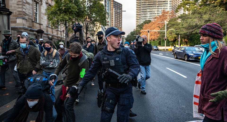 A police officer in Sydney shouting at protesters and looking aggressive. 