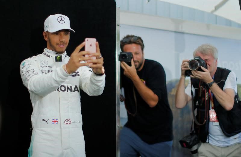 Mercedes driver Lewis Hamilton of Britain takes a selfie during the driver portrait session at the first race of the year - Credit: Reuters