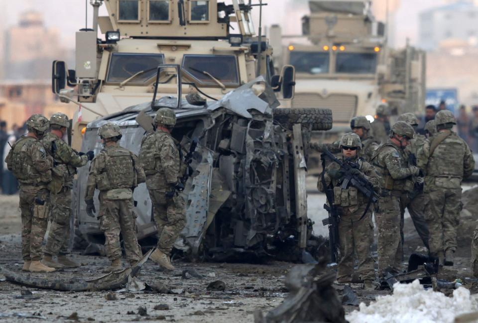 U.S. troops stand guard at the site of a suicide car bomb attack in Kabul