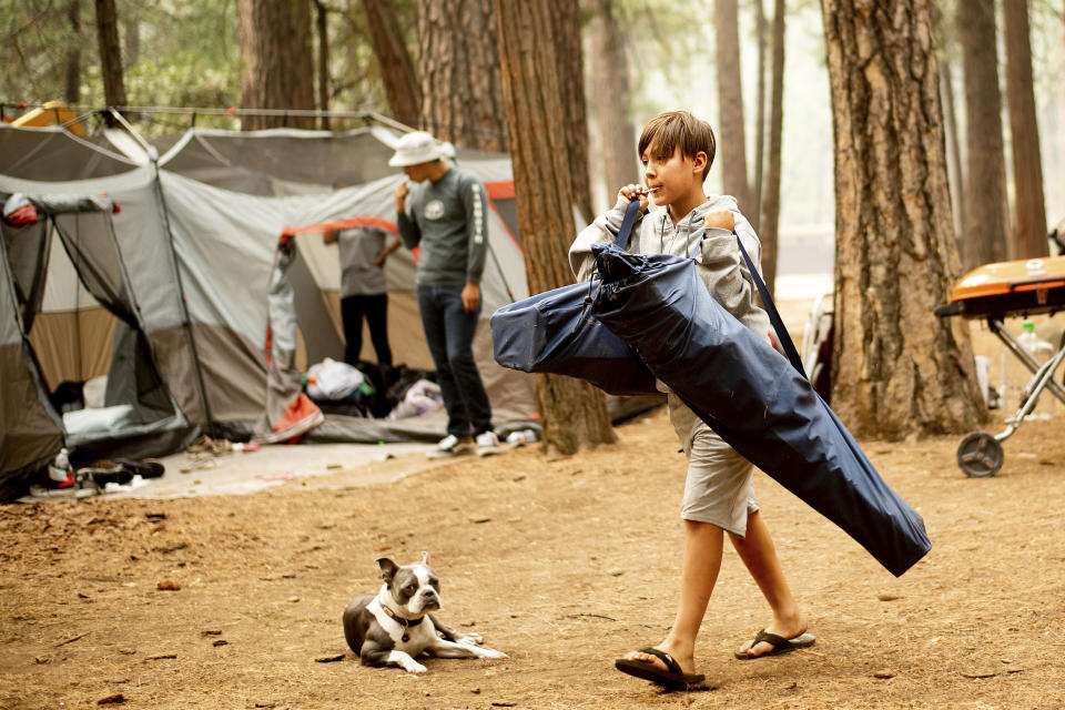 FILE - In this July 25, 2018, file photo, River Martinez, 10, breaks camp at the Upper Pines Campground in Yosemite National Park, Calif. The Interior Department is considering recommendations to modernize campgrounds within the National Park Service. (AP Photo/Noah Berger, File)