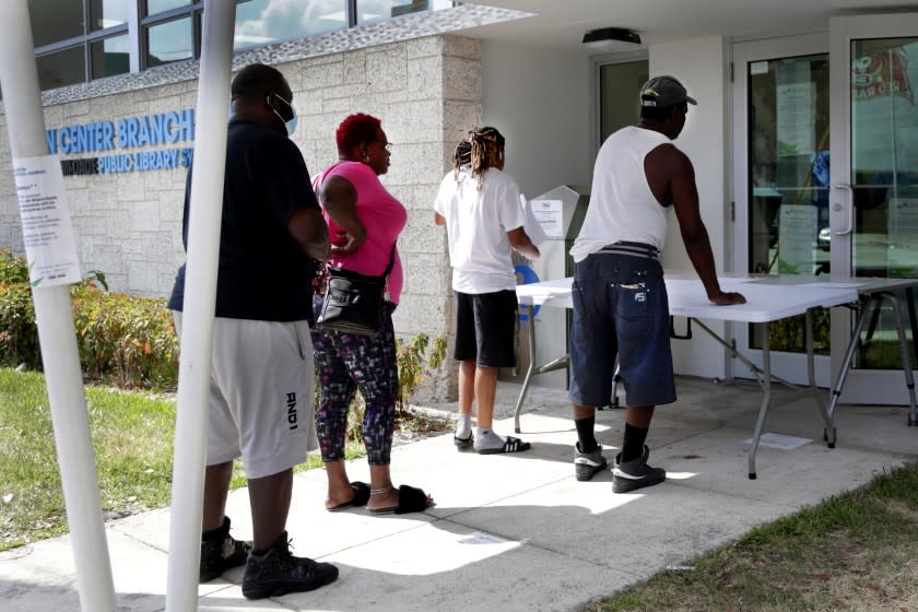 FLORIDA: April 8, 2020, restaurant worker Glen Pile, left, waits in line to get an unemployment form at a Miami-Dade County library during the new coronavirus pandemic in Miami. Pressure has mounted on Florida Gov. Ron DeSantis to make jobless benefits retroactive as the state's newly unemployed continued to be mired in an unemployment system riddled with glitches and uncertainty.