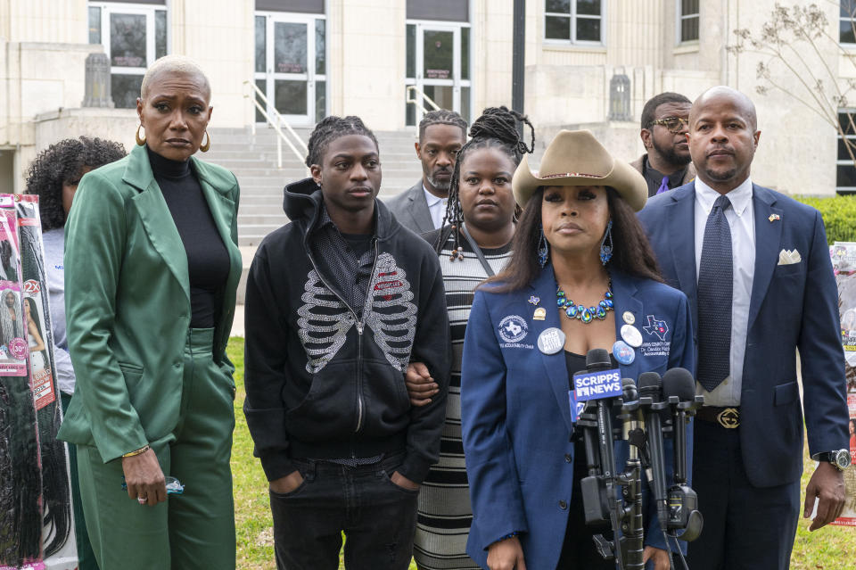 Darryl George, left center, stands with his mother Darresha, right center, as they wait with state representative Jolanda Jones, left, state representative Ron Reynolds, right, and Dr. Candice Matthews before a hearing regarding George's punishment for violating school dress code policy because of his hair style, Thursday Feb. 22, 2024 at the Chambers County Courthouse in Anahuac, Texas. A judge has ruled that George's monthslong punishment by his Texas school district for refusing to change his hairstyle does not violate a new state law prohibiting race-based hair discrimination. (Kirk Sides/Houston Chronicle via AP)