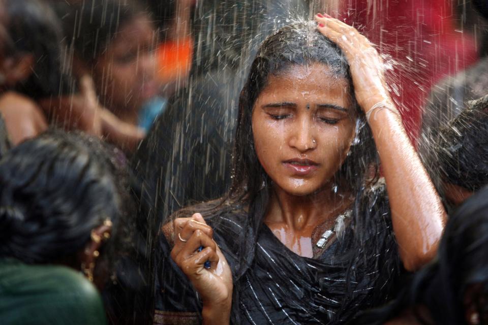 "A young woman bathes in a communal bathing area before worshipping at the Yellamma temple during the Yellamma Jatre (festival) in Saundatti, India. As part of Yellamma custom, all worshippers must wash before worshipping and during the full moon festival."