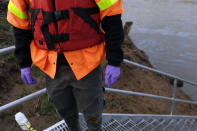 In this Wednesday, Feb. 5, 2014 photo, Didi Fung, a contractor for the Environmental Protection Agency, prepares to collect water samples from the Dan River as state and federal environmental officials continued their investigations of a spill of coal ash into the river in Eden, N.C. Duke Energy estimates that up to 82,000 tons of ash has been released from a break in a 48-inch storm water pipe at the Dan River Power Plant. (AP Photo/Gerry Broome)