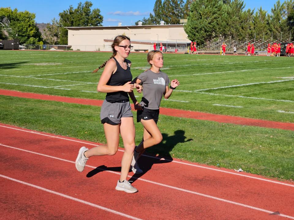 Yreka senior Mattie Whipple (left) runs with sophomore Hailey Hopkins during a post workout on sophomore Hailey Hopkins on Wednesday, Sept. 20, 2023.