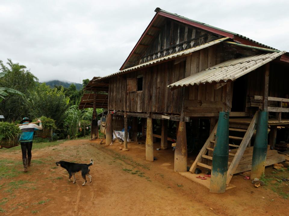 A man walks past a house standing on bombs dropped by the U.S. Air Force planes during the Vietnam War, in the village of Ban Napia in Xieng Khouang province, Laos