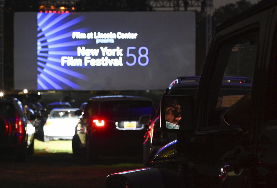 FILE - A filmgoer attends the "Nomadland" screening at the Queens Drive-In at the New York Hall of Science during the 58th New York Film Festival in New York on Sept. 26, 2020. After a historic season, winter is coming at the drive-in. Summer and early fall have seen the old drive-in transformed into a surprisingly elastic omnibus of pandemic-era gathering. Red-carpet premieres that would normally consume Lincoln Center uprooted to drive-ins. (Photo by Evan Agostini/Invision/AP, File)