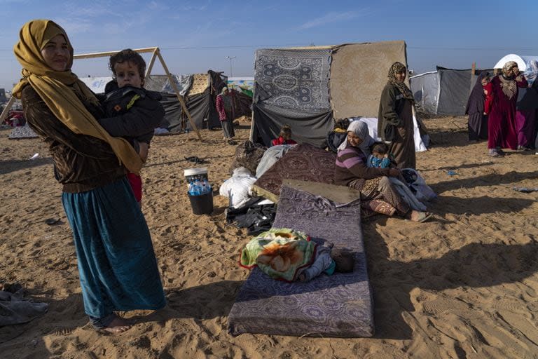 Los palestinos desplazados por los bombardeos israelíes se reúnen en un campamento en Rafah, en el sur de la Franja de Gaza, el lunes 4 de diciembre de 2023. 