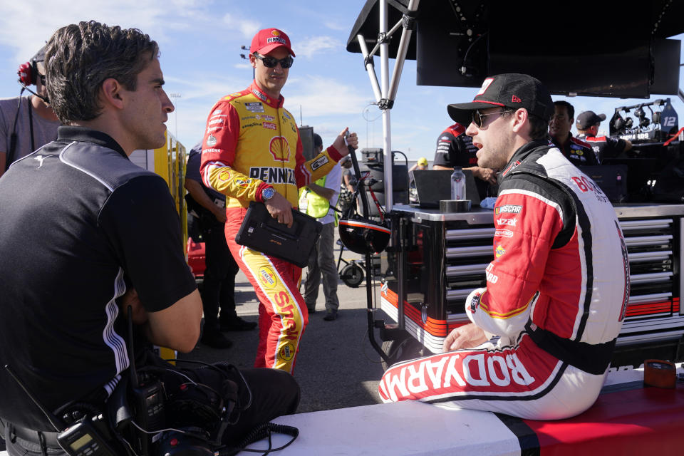 Ryan Blaney, right, and Joey Logano, center, talk with a crew member prior to practice and qualifying at Richmond Raceway for Sunday's NASCAR Cup Series auto race Saturday, Aug. 13, 2022, in Richmond, Va. (AP Photo/Steve Helber)