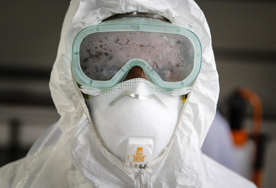 A doctor practices how to use protective equipment before heading to a ward at Mbagathi hospital for patients under quarantine and confirmed cases with the new coronavirus, at Kenyatta National Hospital in Nairobi, Kenya Thursday, April 2, 2020. The new coronavirus causes mild or moderate symptoms for most people, but for some, especially older adults and people with existing health problems, it can cause more severe illness or death. (AP Photo/Brian Inganga)