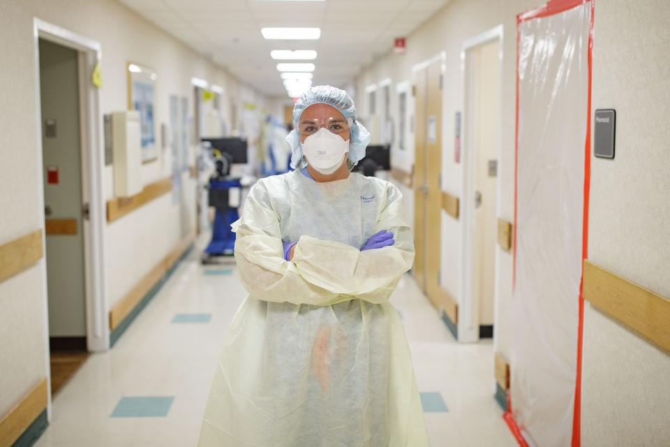 Tallahassee Memorial HealthCare COVID nurse Kelly Clark, 28, poses for a photo in the middle of the hallway in the yellow level COVID unit Monday, Aug. 23, 2021.