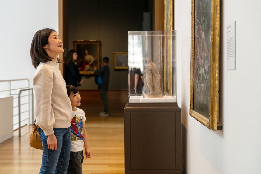 Getty Museum visitors look at a painting.