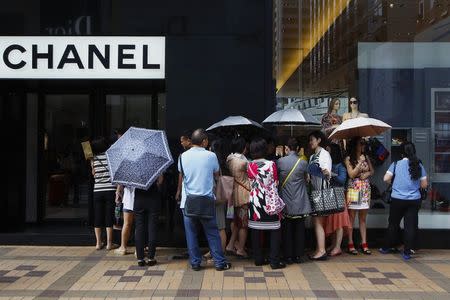 Mainland Chinese tourists wait outside a Chanel store at Hong Kong's Tsim Sha Tsui shopping district October 1, 2014, with part of it being blocked by protesters. Thousands of pro-democracy protesters thronged the streets of Hong Kong on Wednesday, ratcheting up pressure on the pro-Beijing government that has called the action illegal, with both sides marking uneasy National Day celebrations. REUTERS/Liau Chung-ren (CHINA - Tags: POLITICS CIVIL UNREST BUSINESS)