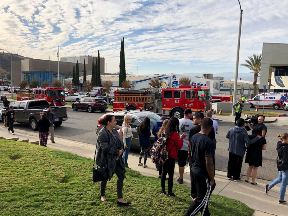 People wait for students and updates outside of Saugus High School after reports of a shooting on Thursday, Nov. 14, 2019, in Santa Clarita, Calif. (AP Photo/Marcio Jose Sanchez)  